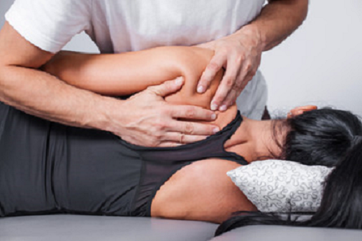 Physiotherapist treating a GAA player's leg injury, representing sports injury care during club championship season